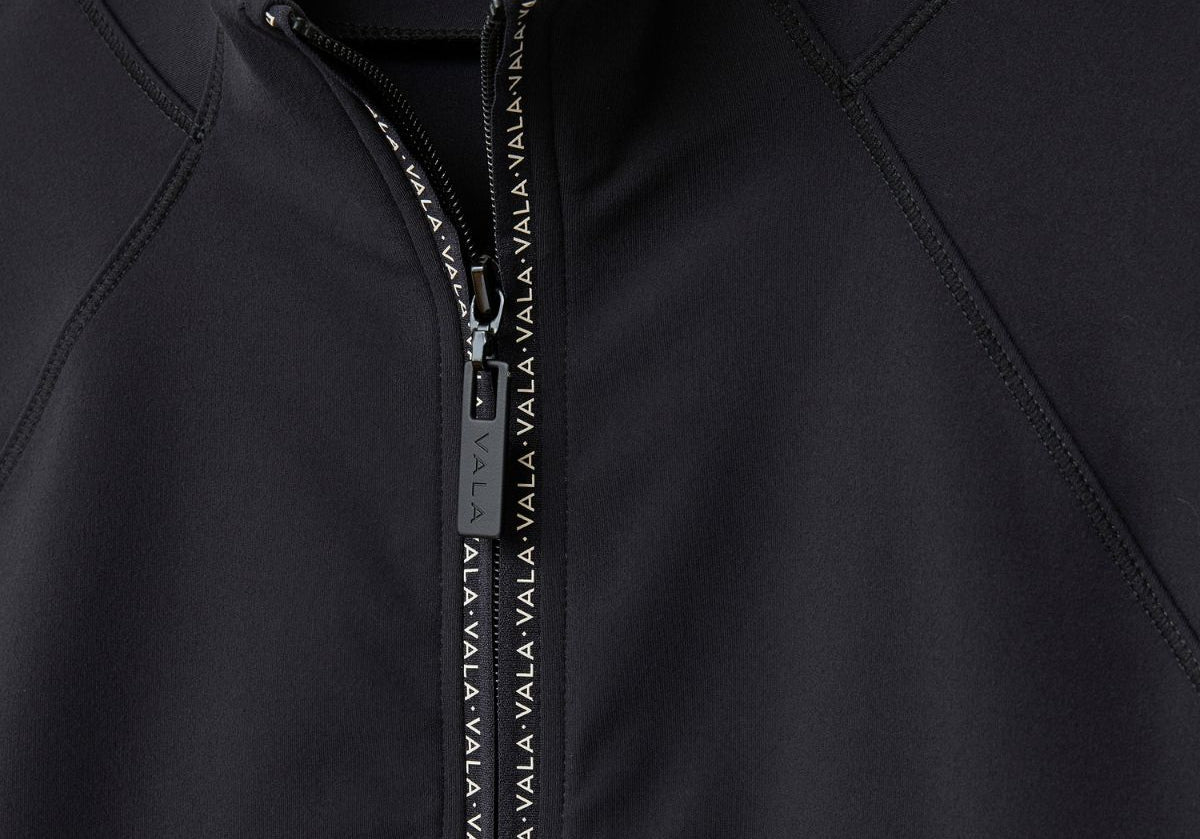 Close-up of Cloudline 1/2 Zip Long Sleeve Top in Black showing zipper detail 1