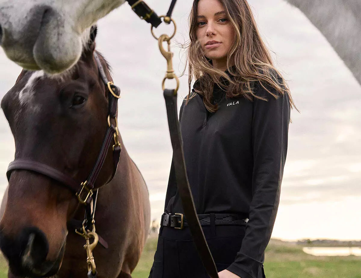 Woman wearing Vala Equestrian long sleeve top with a horse 